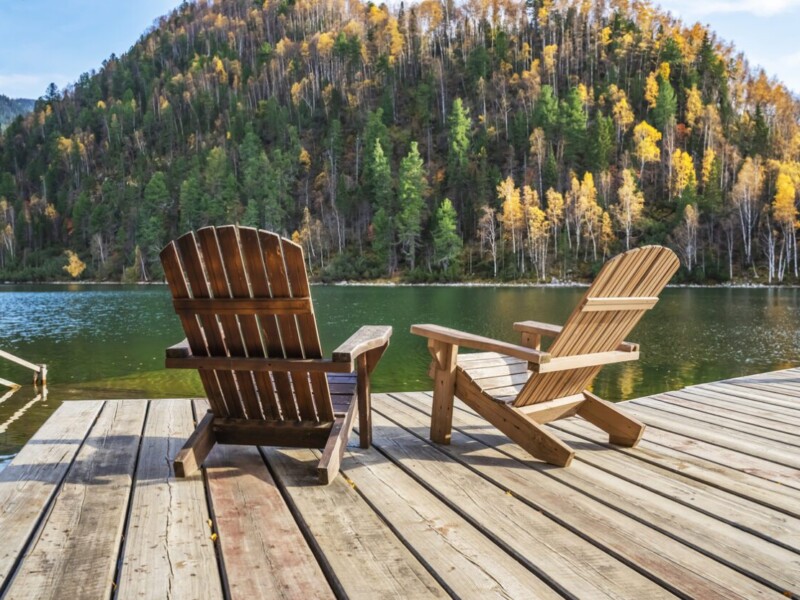 Wooden Adirondack chairs by the lakeside.