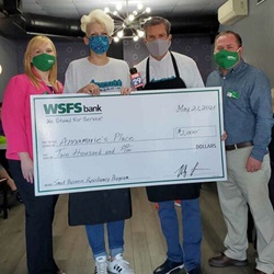 Annamarie Chestnut, owner of Annamarie’s Place, holding a giant check for $2,000 and posing with WSFS Associates and Bob Kelly from FOX29.