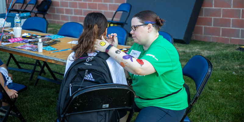 A Team WSFS Associate painting a child’s face at the Philadelphia Union Backpack Carnival.