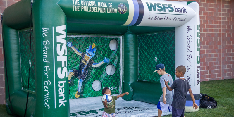 Three children playing a game at the Philadelphia Union Backpack Carnival.