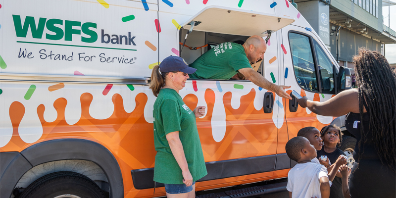 Team WSFS Associates giving ice cream from the WSFS Bank Ice Cream Truck to a family at the Philadelphia Union Backpack Carnival.
