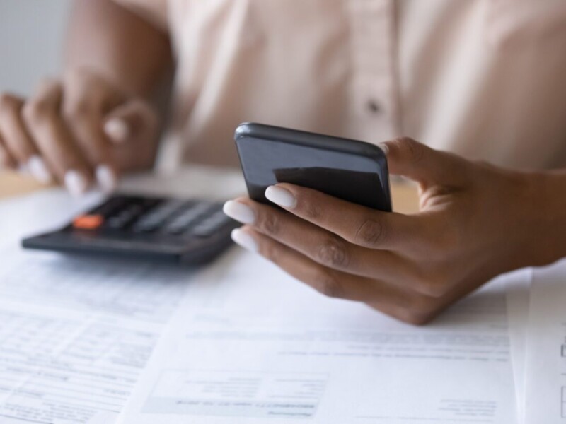 Person using a cell phone and a calculator.