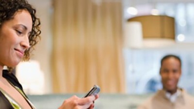 Woman smiling at cell phone.