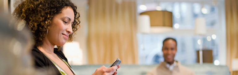 Woman smiling at cell phone.