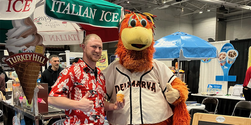A Georgeo’s Water Ice Inc. employee with a mascot at a trade show.