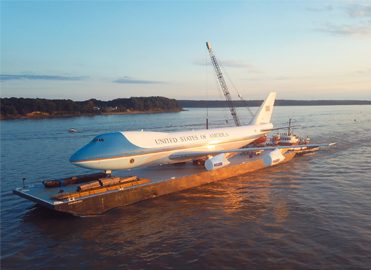 U.S. Air Force One being transported on a barge.