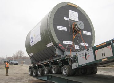 A large piece of machinery being loaded onto a truck.