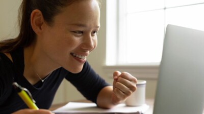 A woman smiling at her computer.