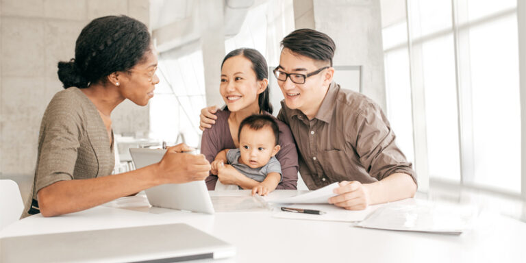 A woman showing a family something on a tablet screen.