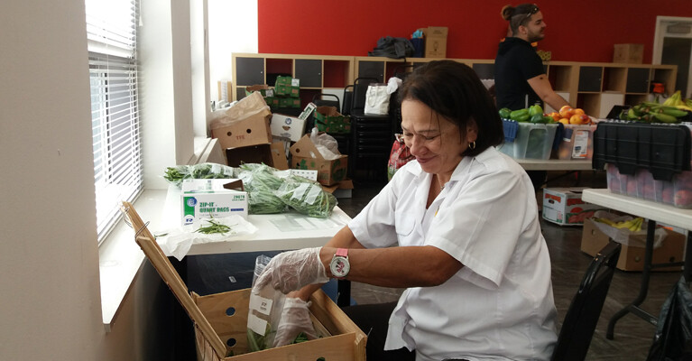 A woman filling a bag with green beans.