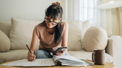 A young woman reviewing her monthly finances.