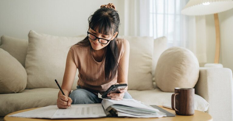 A young woman reviewing her monthly finances.