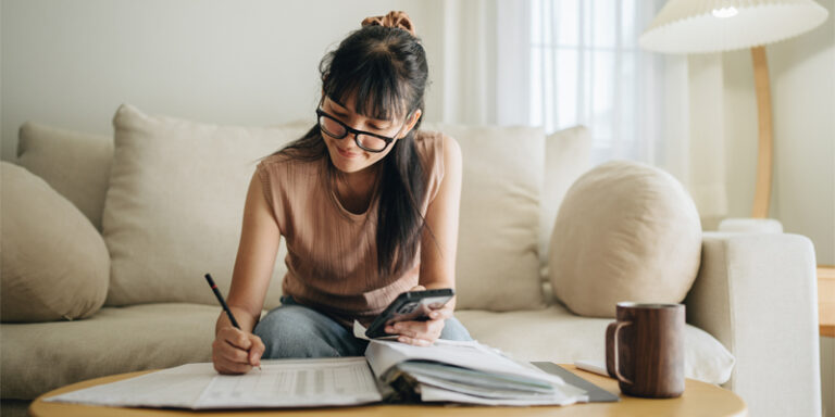 A young woman reviewing her monthly finances.