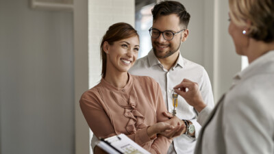 A couple getting the keys to their new home from their real estate agent.