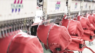 Hats being stitched by embroidery machines.