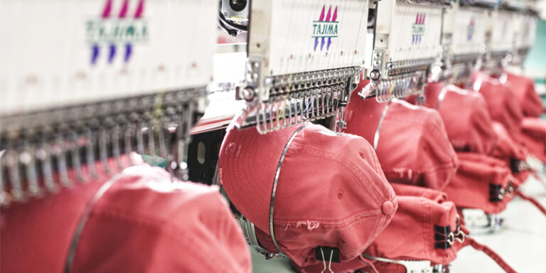 Hats being stitched by embroidery machines.