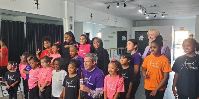 Fox 29 news anchor and WSFS Associate standing with students of Amped Dance Academy.