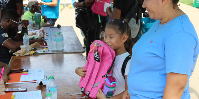 A child receiving a new backpack.
