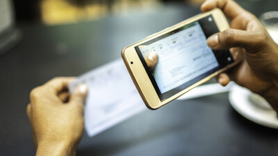 A person taking a picture of a check for mobile deposit.