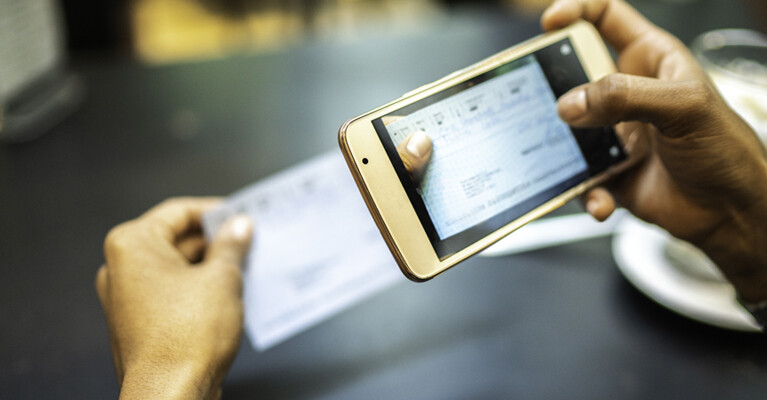A person taking a picture of a check for mobile deposit.