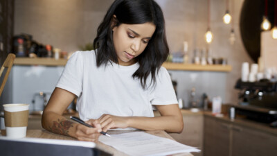 A woman filling out paperwork.