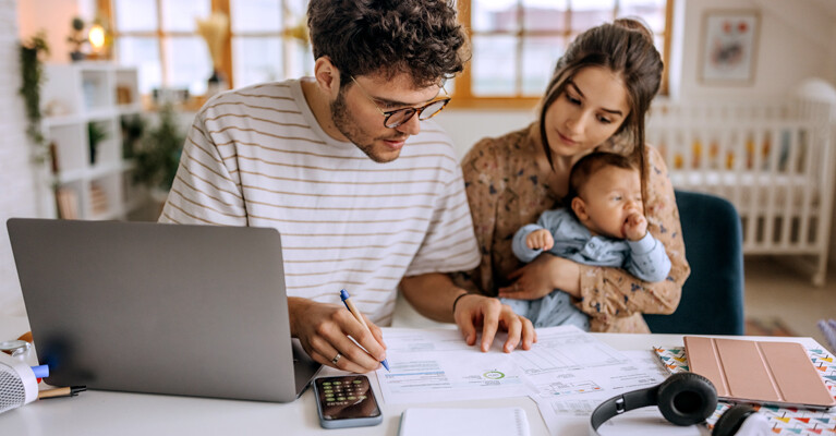 A young couple with their child working on revising their monthly budget.