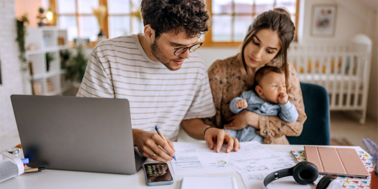 A young couple with their child working on revising their monthly budget.