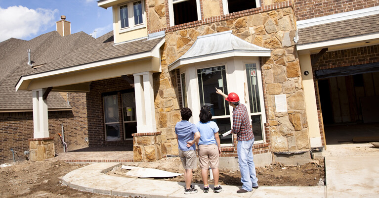 A couple talking with the construction manager for their new home.