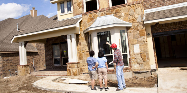 A couple talking with the construction manager for their new home.