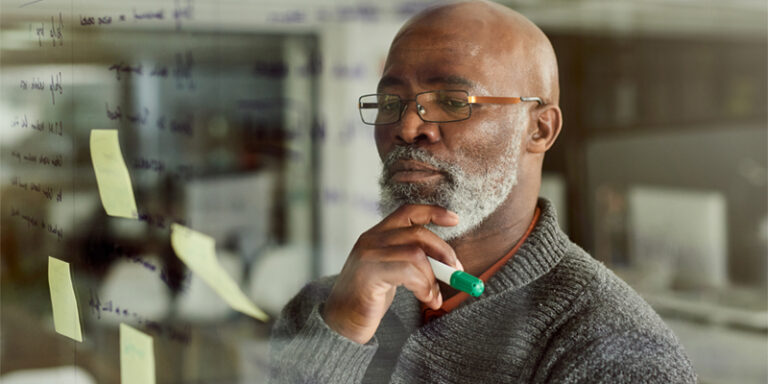 A man looking at notes on a whiteboard.