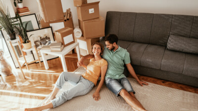 A couple relaxing amongst moving boxes in their new home.d