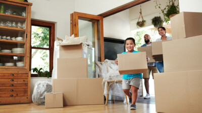 A family carrying boxes into their new house.