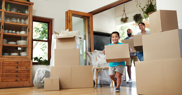 A family carrying boxes into their new house.