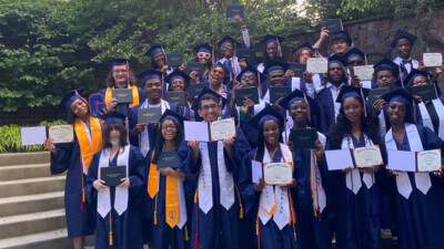 A group of graduates holding their diplomas.