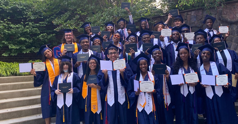 A group of graduates holding their diplomas.