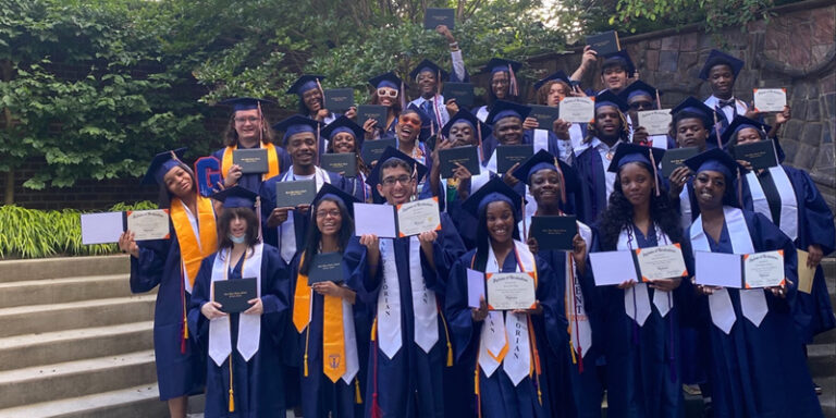 A group of graduates holding their diplomas.