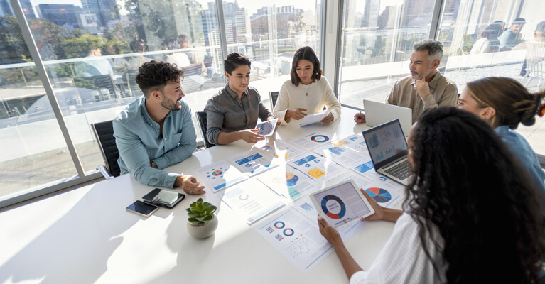 A group of businesspeople reviewing charts at a conference table.