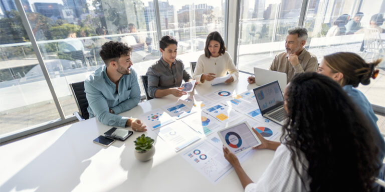 A group of businesspeople reviewing charts at a conference table.