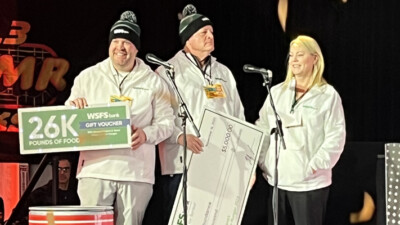 A photo of WSFS Bank Associates holding an oversized check for $5,000 and a voucher for 26,000 pounds of food to donate to Philabundance.