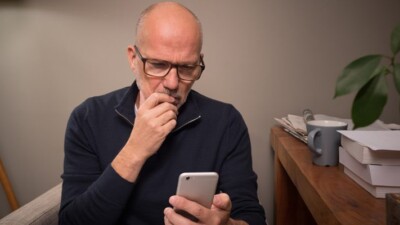 Man looking thoughtfully at cell phone.