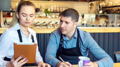 Two cafe managers looking at a tablet.