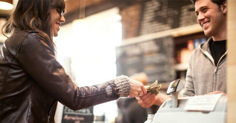 A woman paying at a cash register.