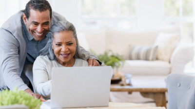 A man and a woman using a laptop.