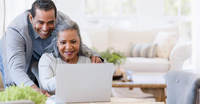 A man and a woman using a laptop.