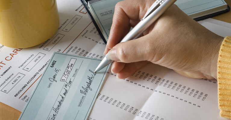 A person signing a check for $1500.