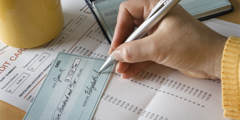 A person signing a check for $1500.