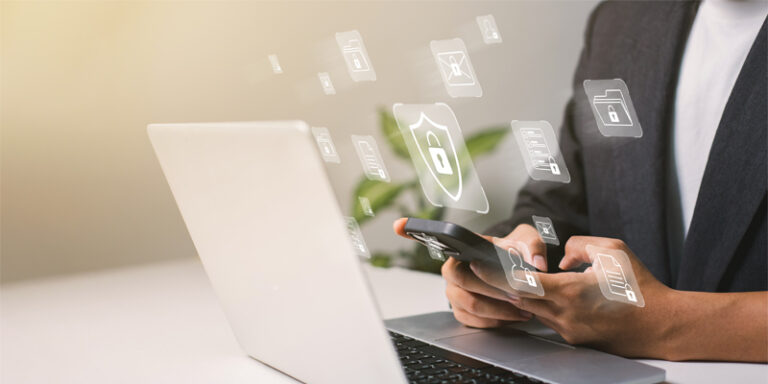 A person using a laptop and smartphone with security icons.