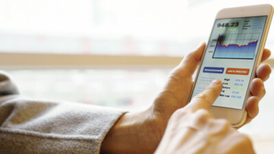 Man looking at stocks on cell phone.