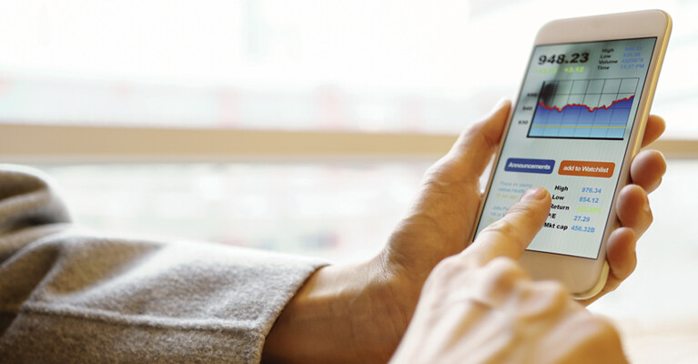 Man looking at stocks on cell phone.