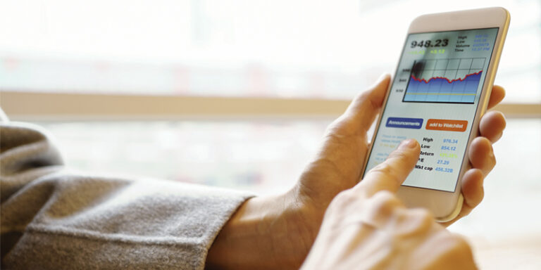Man looking at stocks on cell phone.
